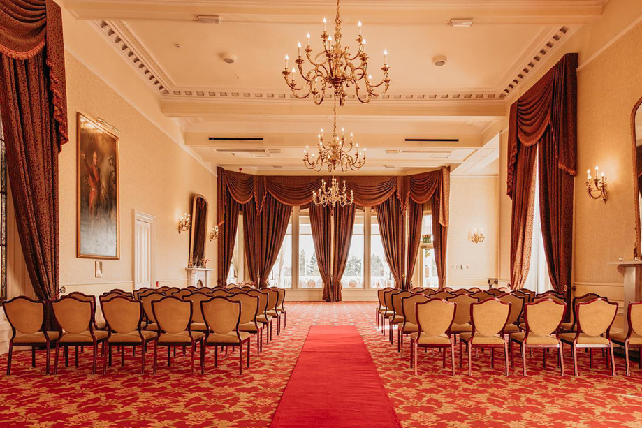 Ceremony room set up with draped curtains, paintings and chandeliers