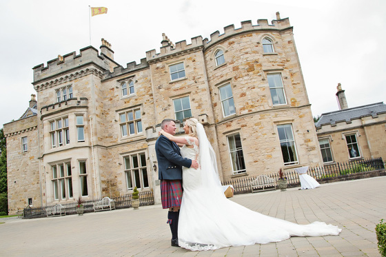 Bride and groom looking at each other outside Crossbasket Castle