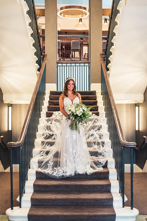 Bride stands on stairs at The Clayton Hotel in Glasgow
