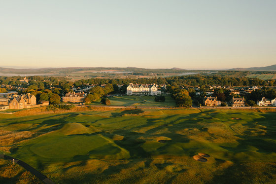 Aerial view of Dornoch Station Hotel wedding venue with championship golf course in the foreground and Scottish Highlands landscape beyond