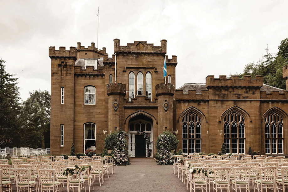 Outdoor wedding ceremony set up at the entrance of Drumtochty Castle, Aberdeenshire, with guest seating and floral styling.