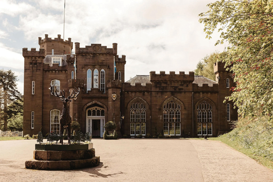 View of Drumtochty Castle entrance in Aberdeenshire with statue in the foreground, a grand Scottish castle wedding venue.