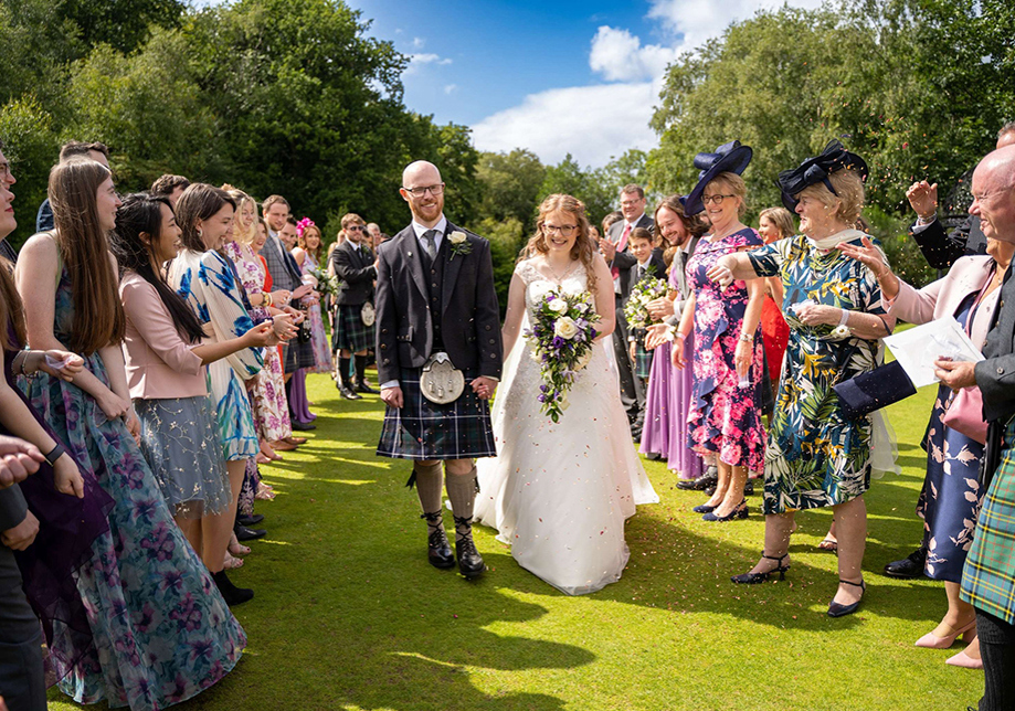 Bride and groom walk back down the aisle after outdoor ceremony