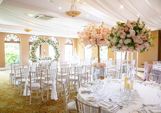 Ceremony and wedding meal set up with floral circle at altar and cherry blossom tree at end of aisle