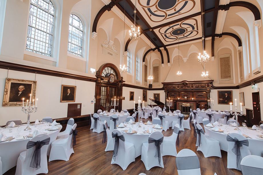 Wedding meal set up with candelabra's on tables and black, sheer organza bows on seats