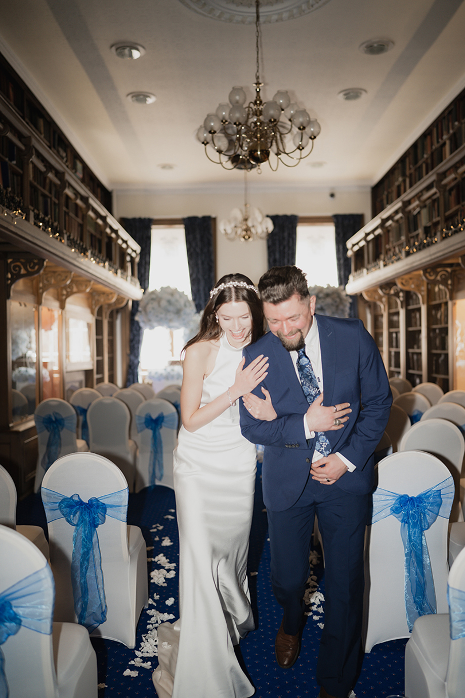 Bride and groom laugh as they walk back up aisle at 1599 at the Royal College.