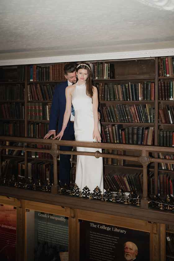 Bride and groom pose in library at 1599 at the Royal College.