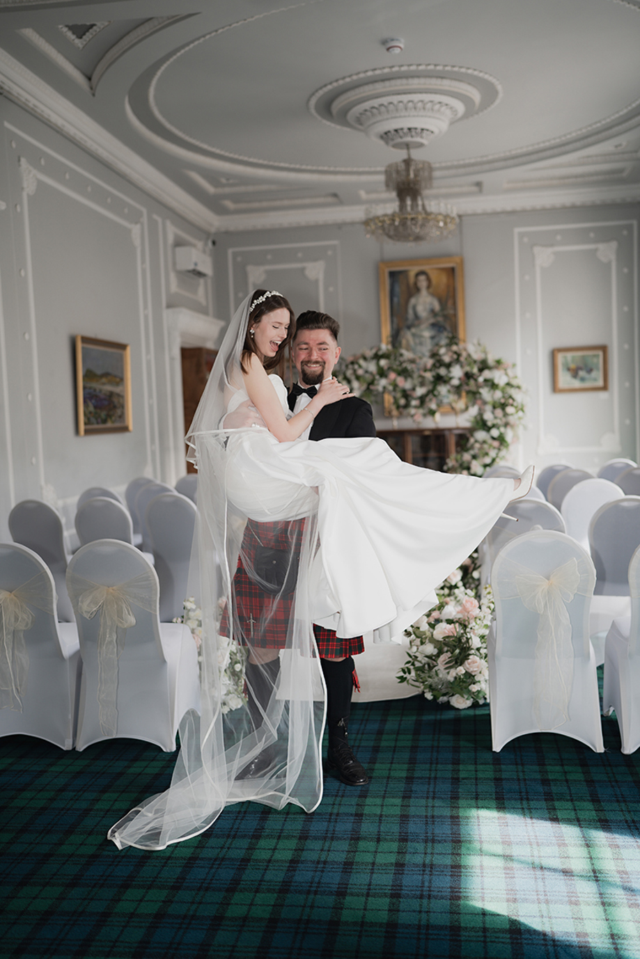 Groom carries bride back up the aisle at 1599 at the Royal College.