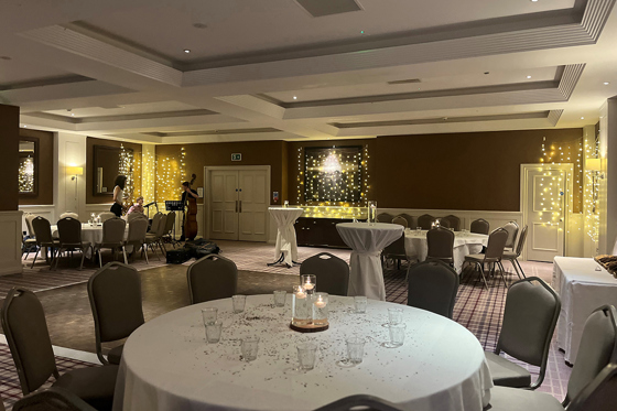 Wedding reception set up in the Swilcan Suite Ballroom, with round tables and fairy lights.