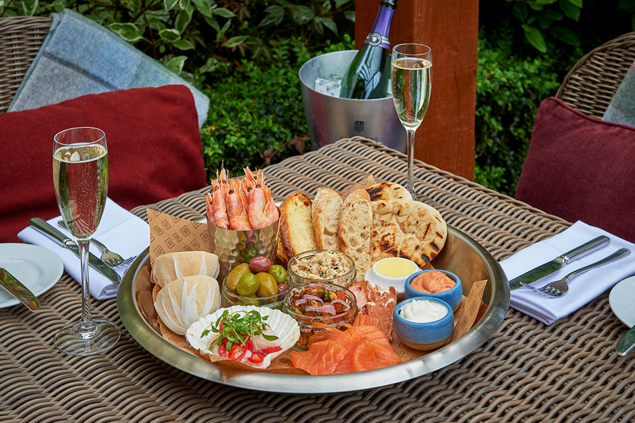 Bucket and ice with champagne, filled glasses and seafood platter