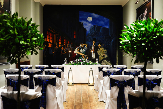 Ceremony room with blue bows on seats and mural on wall