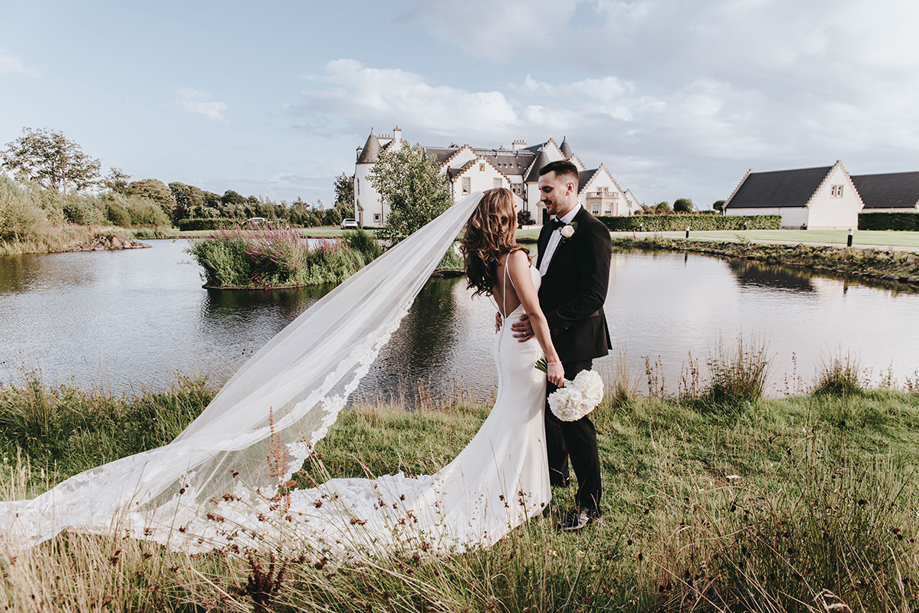Bride and groom beside loch at Ingliston Estate and Country Club wedding venue near Glasgow