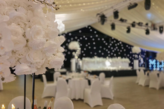 Elegant wedding reception styling with black starcloth backdrop and floral centrepieces at Ingliston Estate