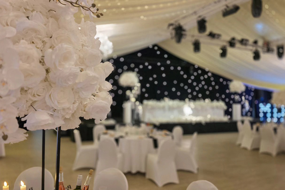 Elegant wedding reception styling with black starcloth backdrop and floral centrepieces at Ingliston Estate