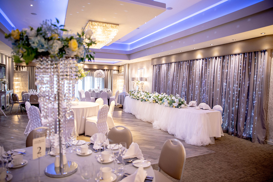Modern wedding reception room with floral top table styling at Ingliston Estate and Country Club
