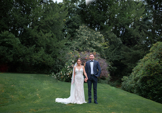 Bride and groom hold hands on grounds of Kilmardinny House