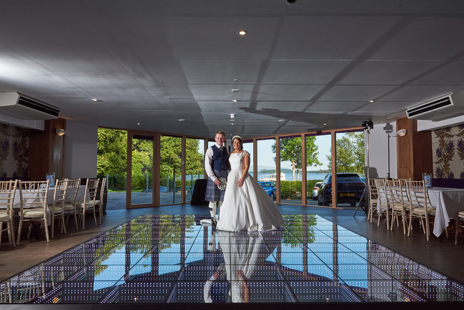 Bride and groom pose on dancefloor at Lodge on Loch Lomond.