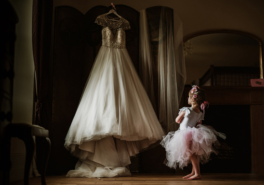 Little girl in tutu looking at wedding dress hanging up in Aberdeen Wedding Venue Logie Country House