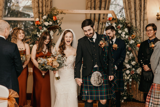 Happy newlyweds walk back down aisle after ceremony at Norwood Hall Hotel