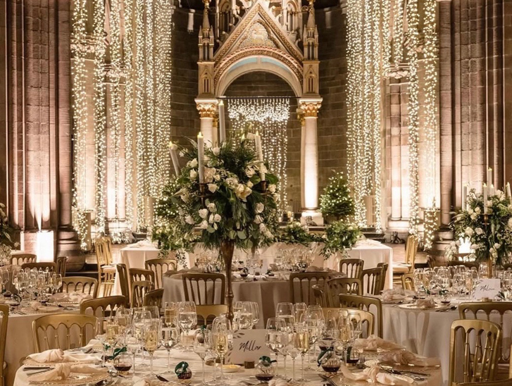 Wedding reception set up inside Mansfield Traquair Edinburgh with fairy lights, gold chairs and white floral centrepieces