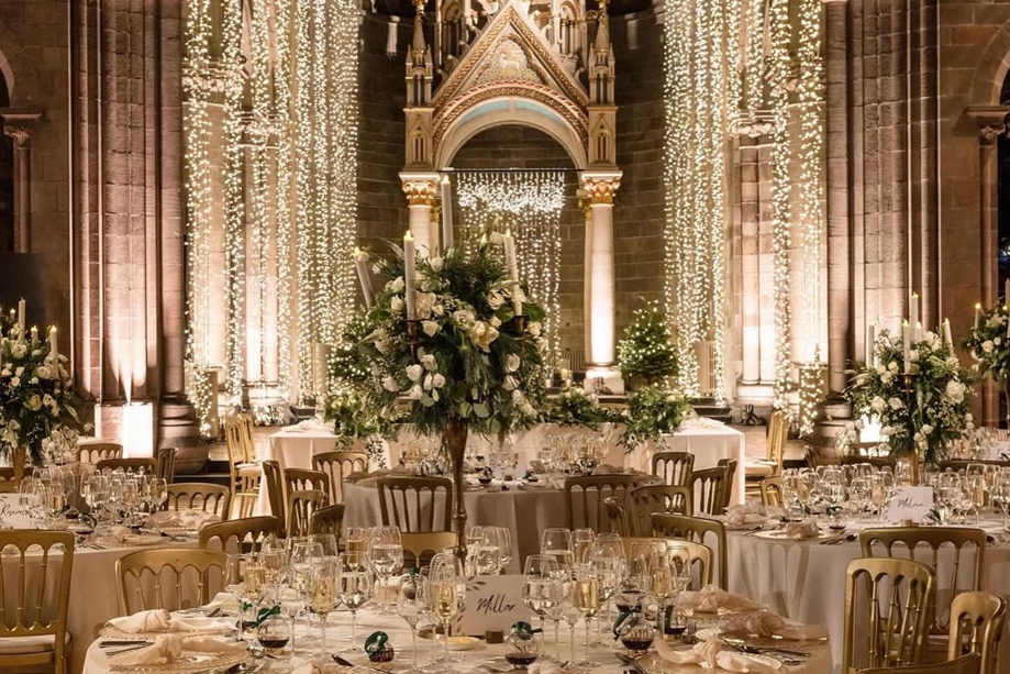 Wedding reception set up inside Mansfield Traquair Edinburgh with fairy lights, gold chairs and white floral centrepieces