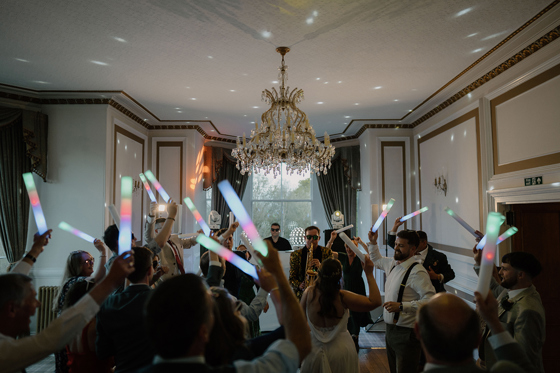 Saxophonist performing at a lively wedding reception inside Auchen Castle.