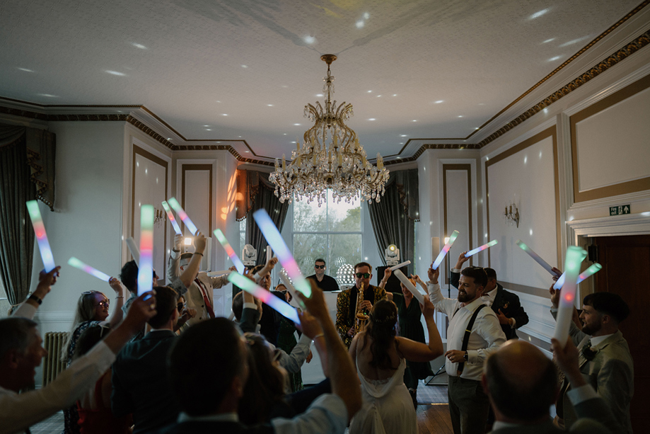 Saxophonist performing at a lively wedding reception inside Auchen Castle.