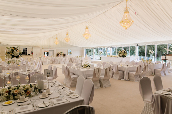 Wedding meal set up with chandeliers and flowers on round tables
