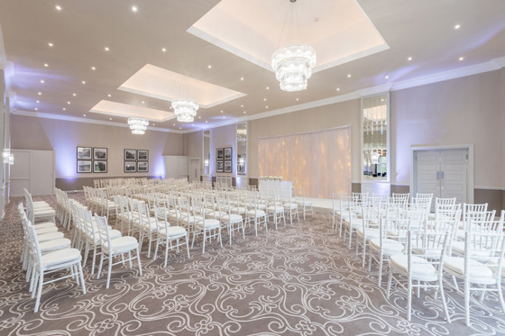 Ceremony room with white colour scheme and chandeliers