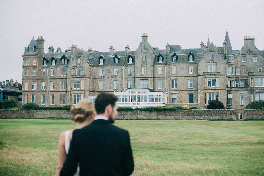 Couple walking on the lawn in front of Marine North Berwick hotel wedding venue in Scotland