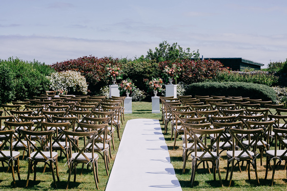 Outdoor wedding ceremony set-up at Marine North Berwick with wooden chairs and floral plinths in the garden