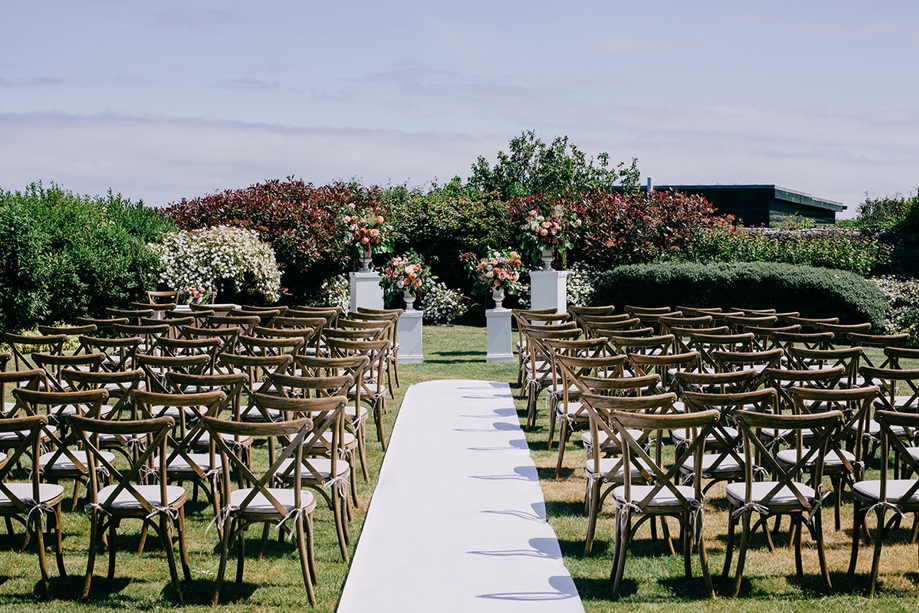 Outdoor wedding ceremony set-up at Marine North Berwick with wooden chairs and floral plinths in the garden