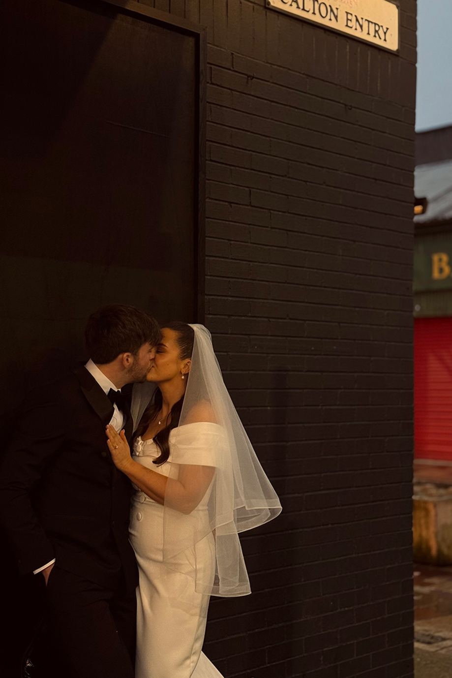 Bride and groom share a kiss on the corner of Calton Entry in the Barra's.
