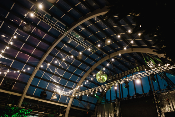 View of ceiling with large disco ball and draped festoon lights at BAaD in Glasgow.