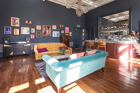 Colourful lounge bar at Netherbyres House with velvet sofas, marble-topped bar and eclectic artwork, ideal for wedding receptions
