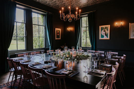 Intimate dining room setup at Netherbyres House wedding venue with candlelit tables, floral centrepieces and candelabra lighting
