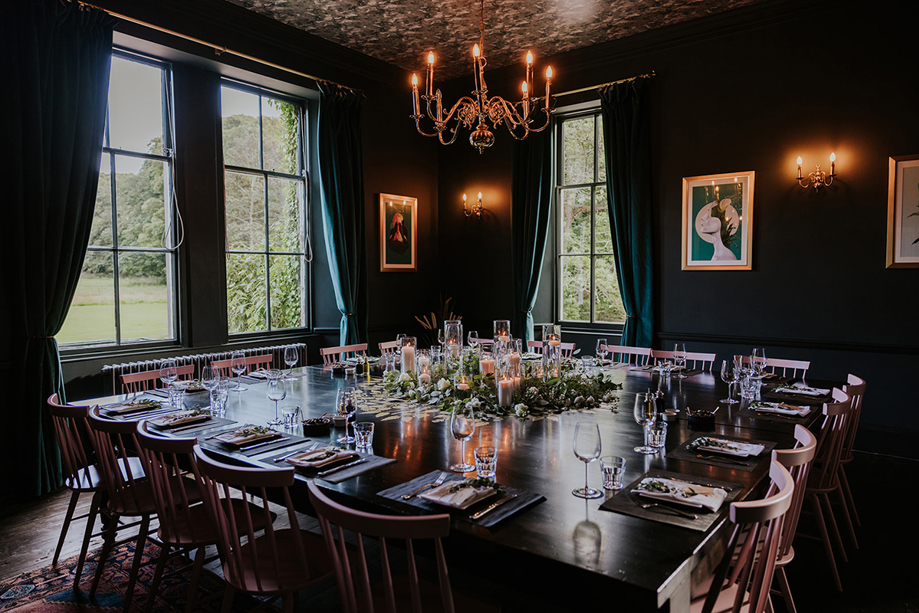 Intimate dining room setup at Netherbyres House wedding venue with candlelit tables, floral centrepieces and candelabra lighting