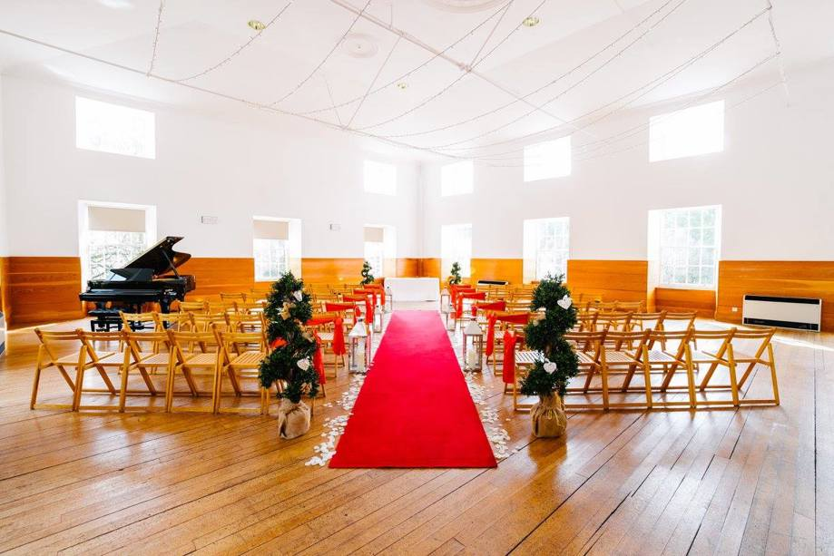 Ceremony with piano and red carpet aisle