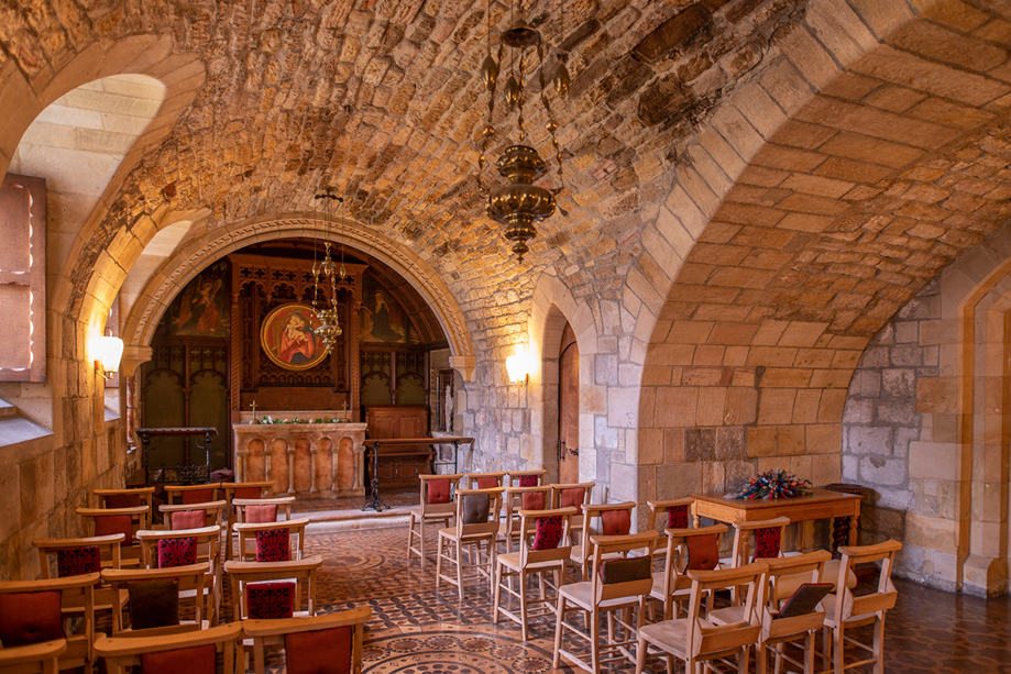 Chapel ceremony space at Newbattle Abbey College with stone arches altar and intimate seating for weddings