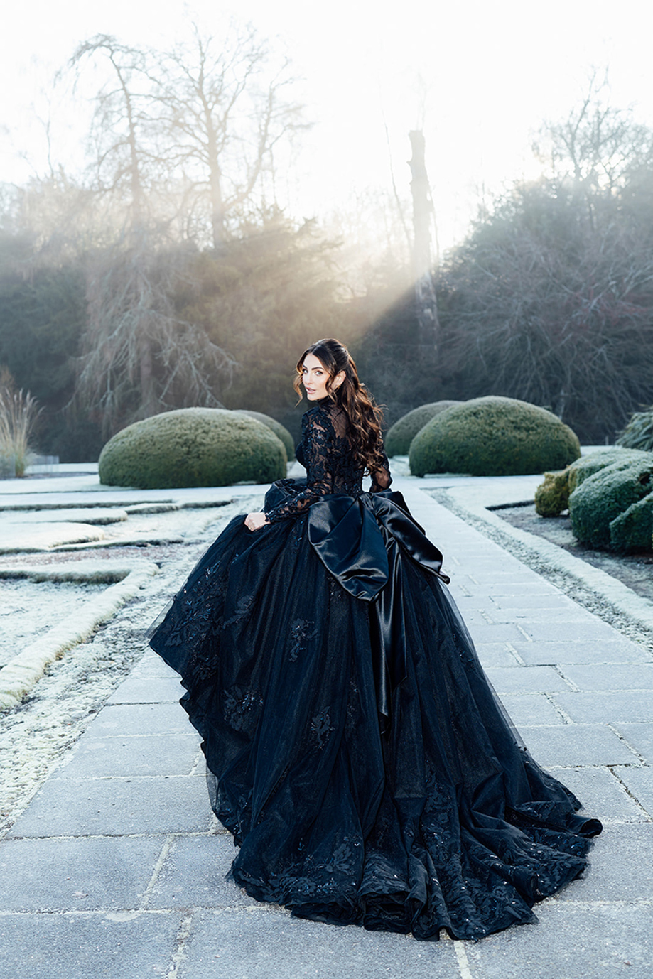 Bride wearing black wedding dress in formal gardens at Newbattle Abbey College during winter editorial shoot