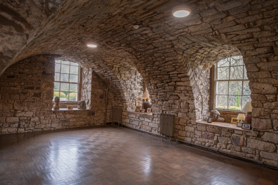 Stone vaulted room at Newbattle Abbey College with arched ceiling and wooden floors for wedding reception or drinks