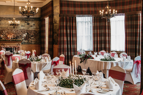 Bannockburn Suite set up for wedding meal with red accents and tartan