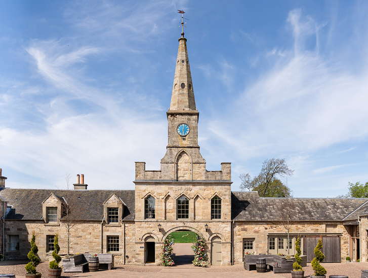 Historic stone entrance and clock tower at Rosebery House exclusive-use wedding venue in Scotland