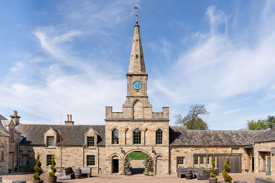 Historic stone entrance and clock tower at Rosebery House exclusive-use wedding venue in Scotland