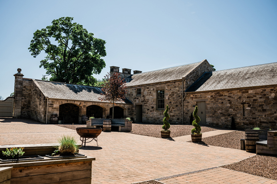 Courtyard and stone buildings at Rosebery House wedding venue in Midlothian countryside