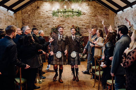 Newlywed couple walking down the aisle after ceremony at Rosebery House wedding venue in Midlothian