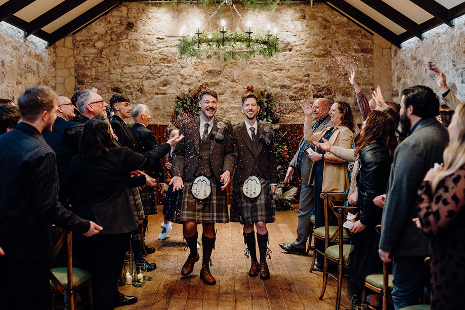 Newlywed couple walking down the aisle after ceremony at Rosebery House wedding venue in Midlothian