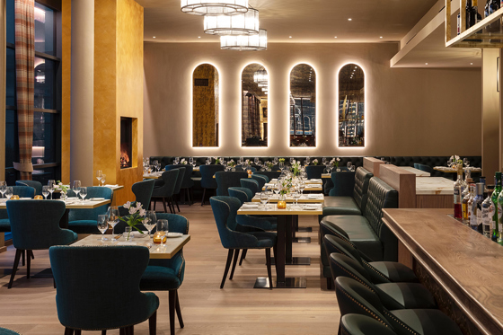 Charlie's restaurant interior with modern decor and four arched mirrors on wall with back lighting.
