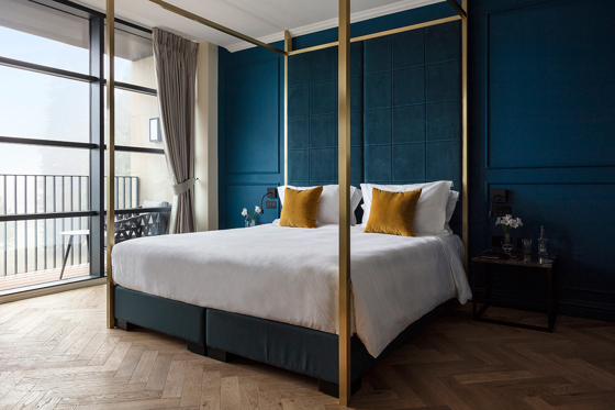 SCHLOSS Roxburghe suite with gold four poster bed and dark teal walls.