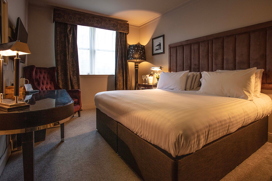 Elegant guest bedroom at Strathaven Hotel with king bed and warm décor, ideal on-site accommodation for wedding guests in South Lanarkshire.